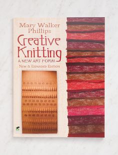 a book about creative knitting on a white table with red and brown stripes in the background