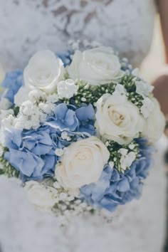 a bridal holding a bouquet of white and blue flowers