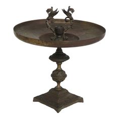 an old fashioned metal tray with two birds on the top and one bird in the middle