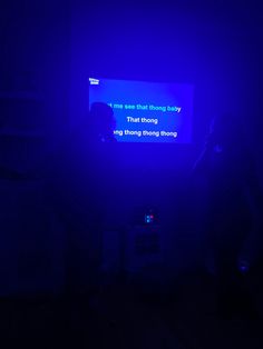 a person standing in front of a tv with a blue light on it's screen