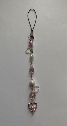 a key chain with hearts and charms hanging from it's side on a white surface