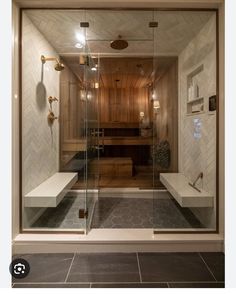 a bathroom with a walk in shower next to a tiled floor and wall mounted lights