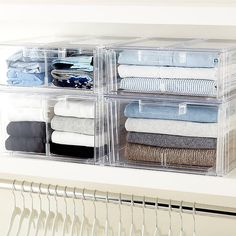 an organized closet with clear drawers and clothes