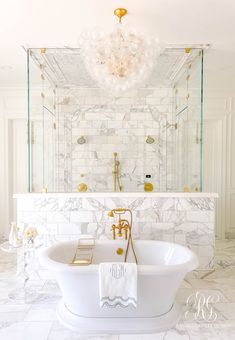 a white bath tub sitting in a bathroom next to a chandelier