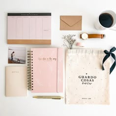 the contents of a personal planner laid out on a white table with a cup of coffee