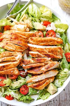 a salad with chicken, lettuce and tomatoes