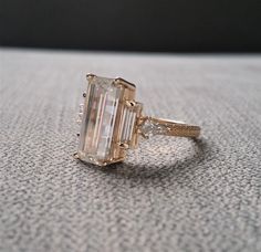 an emerald cut diamond ring on a table