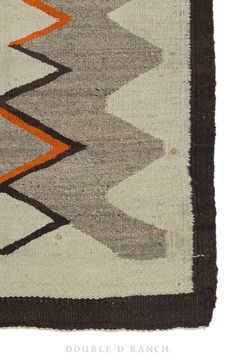 an old rug with different colors and patterns on it's sides, including brown, gray, orange, and white