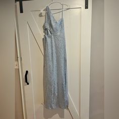 a blue dress hanging on a white door with a hanger in front of it