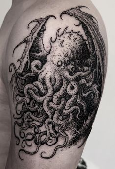 an octopus tattoo on the back of a man's left arm, with black ink