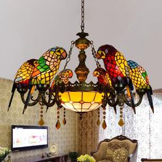 a chandelier hanging from the ceiling in a living room with two parrots on it