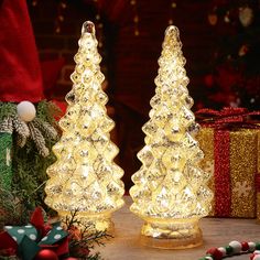 two lighted christmas trees sitting next to each other