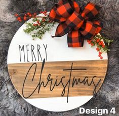 a merry christmas sign hanging on the side of a door with red and black ribbon