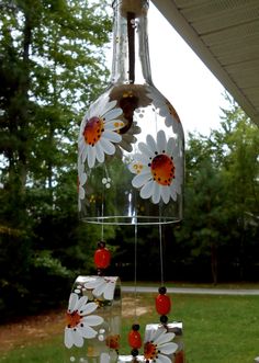 a glass vase with flowers hanging from it's side in front of a house