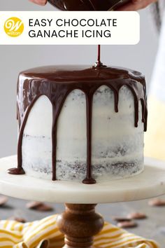 someone is decorating a cake with chocolate ganache icing on the top and bottom