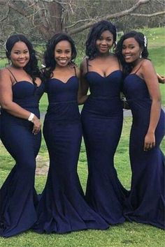 four women in blue dresses posing for the camera with one woman wearing a black dress