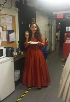 a woman in an orange dress holding a plate