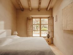 a bedroom with a large bed and an open window in the wall next to it