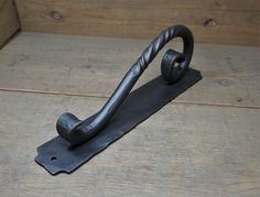 an iron hook on top of a wooden floor