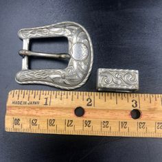 "A set of 3 silver tone metal southwestern/cowboy style belt buckle parts. I'll do my best to describe these but I have to admit that I know nothing about using these to ornament a belt. I just fell in love with the color and details on these pieces. I also am not able to identify the metal. All three definitely look vintage, have wear, and have tarnished over time. Please refer to the photo numbers for the measurements given below: Photo #3 Belt Buckle - There's a small circle with the head of Western Silver Belt With Antique Buckle, Engraved Adjustable Western Belt Buckles, Silver Concho Belt Buckles For Rodeo, Vintage Silver Belt Buckles For Rodeo, Vintage Adjustable Belt Buckles For Rodeo, Vintage Silver Belt Buckle For Rodeo, Antique Silver Buckle Belt Buckles For Ranch, Vintage Silver Belt Buckles For Western-themed Events, Adjustable Engraved Belt Buckles For Rodeo