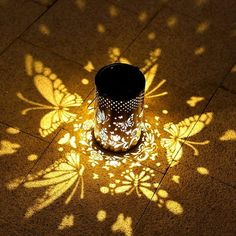 a candle that is sitting on the ground with some light coming from it's shadow