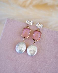 Add a touch of elegance and feminine flair to your wedding day look with our stunning Arabella Pink Drop Earrings. These beautiful gold and pink drop earrings feature eye-catching freshwater coin pearls, making them a perfect choice for the boho bride who wants a pop of color to her wedding look.Crafted with high-quality materials, these drop earrings are designed to last for years to come. The delicate design and modern glam appeal makes them perfect for brides who want to keep it simple yet el Feminine Pink Pearl Drop Earrings, Pink Teardrop Pearl Earrings For Formal Occasions, Elegant Pink Teardrop Pearl Earrings, Pink Teardrop Pearl Drop Jewelry, Feminine Pink Jewelry With Pearl Drop, Glamorous Pearl Charm Jewelry For Gifts, Glamorous Pearl Charm Jewelry Gift, Glamorous Jewelry With Pearl Charm For Gift, Feminine Pink Pearl Drop Jewelry