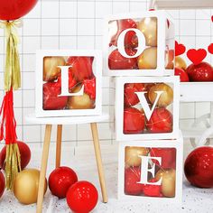 valentine's day decorations and balloons on display in front of white tiled walls with red and gold accents