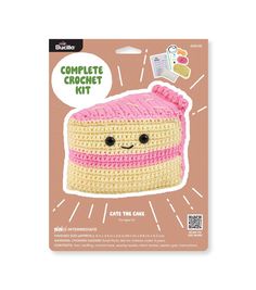 a crochet kit with a pink and yellow cake on it's side