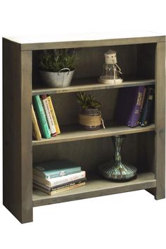 a book shelf with books and plants on it