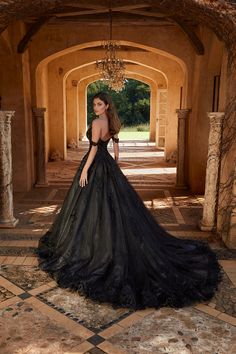 a woman in a black dress is standing on the floor with her back to the camera