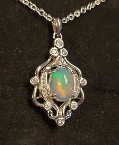 "Gorgeous Natural Rainbow Ethiopian Opal 8x10mm with Full Rainbow  Fire! The Opal In The Photos And Video Is An Example Of Available Stones Color And Quality Stones Vary. You Can Ask To See Stones. Be Sure To See Video! 925 Sterling Silver Rococo Chandelier Necklace With 9+ CZ Accents Giving Sparkle. 20\"  Sterling Silver Chain. Several Chain Length Options Ask Seller About Availability. Great Gift! Gift Box Included" Silver Oval Necklace With Bail, Silver Oval Multi-stone Necklaces, Oval Silver Multi-stone Necklaces, Sterling Silver Oval Cabochon Multi-stone Jewelry, Sterling Silver Multi-stone Jewelry With Oval Cabochon, Silver Necklace With Bail In Fine Jewelry Style, Rococo Chandelier, Chandelier Necklace, Full Rainbow