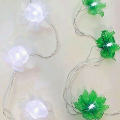 three green and white flower lights are on the wall