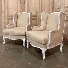 two chairs sitting next to each other in front of wooden paneled walls and flooring