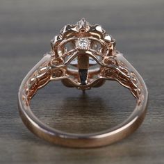 a close up of a ring on a wooden table with a diamond in the center