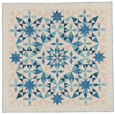 a blue and white quilt with stars on the front, in shades of pink and blue