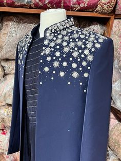 Midnight blue exclusive embellished with intricate pearl, stone, zari and cutdana work, this sherwani speaks volume of class. Commingled with blue color kurta for the complete ensemble. This jacket sherwani is a unique style that we loved. Even the color is fresh and looks royal. Size: 42,44 Occasion: Wedding Ceremony or Reception WASH CARE INSTRUCTIONS - Please Dry clean only when it is applicable. Slight color variation is possible due to digital photography. Ready to Ship! Festive Designer Sets With Pearl Embroidery, Embellished Sherwani With Traditional Drape For Designer Wear, Embellished Sherwani For Designer Wear With Traditional Drape, Unstitched Pearl Embroidered Sherwani With Traditional Drape, Embellished Unstitched Sherwani For Eid, Elegant Sherwani With Pearl Embroidery For Diwali, Elegant Traditional Wear With Stone Work For Designer Occasions, Traditional Embellished Unstitched Suit For Reception, Formal Bollywood Kurta With Pearl Embroidery