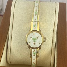 Vintage 1950's Flip Top Bucherer 17 Jewels Swiss Ladies Floral Enameled Cuff Wrist Watch 18k Heavy Gold 10 Micron Gold Plated Marked By Inside Back Underside 12 O'clock. Hinged Case Lid Stays Tightened. This Bucherer Watch Has A Larger Crown, Runs, Hand Wind, Gold Fleur D'alain, Raised Green Dots, Cream Enamel. Has A New Crystal, There Are Some Very Light Scuffs To Bracelet It Has Good Springs And Can Fit Up To A Size 6.85 Marked 36u C-Cr Excellent Condition As All Vintage Watches Slight Variation In Time Keeping Can Be Off Tested For 8 Hours Keeping Time Womens Watches Vintage, White Retro Watch For Formal Occasions, Retro White Watches For Formal Occasions, White Retro Formal Watch, White Retro Formal Watches, Italy Outfits, Cuff Watch, Green Dot, Cream And Gold