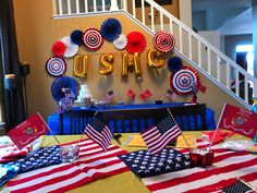 the table is set up with american flags and decorations for an patriotic themed party or celebration