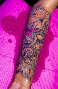 a woman's arm with flowers on it and a butterfly in the middle of her arm