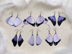 six pairs of purple and black butterfly earrings on white furnishing with chinese characters in the background