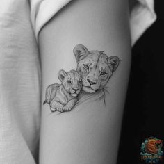 a woman's thigh with a small tattoo of two lions on the side of her leg