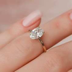 a woman's hand holding a diamond ring