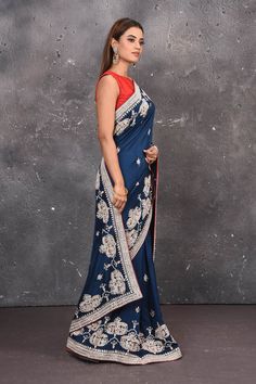 Look elegant adorning this navy blue color art silk saree beautified with gota patti and thread work embroidered floral designs all over along with its distinctive heavily detailed border and pallu. A scalloped border is given a grand look with a beautiful floral setting blossoming with colourful threadwork of flowers, gota patti leaves and dazzling cut dana and mirror work details. Mirror bootis are scattered all over the saree to match the brightness of the happy look. DISCLAIMER:- The shown s Scalloped Border, Embroidered Saree, Fashion Journals, Designer Sarees Online, Art Silk Sarees, Traditional Fabric, Blue Soft, Color Art, Mirror Work