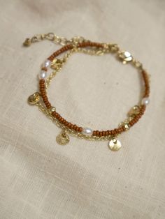 This beaded bracelet gives you the two-in-one layered look with a subtle shimmer of pearl and pops of gold. Perfect for adding to your favorite stack of layered wrist accessories. Seed beads, freshwater pearls, and brass 7" length Made fair trade in India by one of our longstanding production partners Pretty Earrings Dangle, Amber Bead Necklace, Wrist Accessories, Floral Studs, Silver Ring Set, Gold Flecks, Gold Ring Sets, Earring Tree, Amber Beads