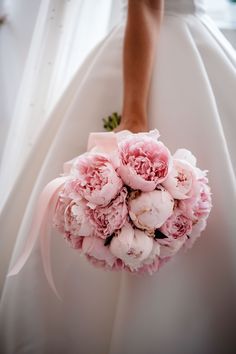 the bride's bouquet was made up of pink peonies