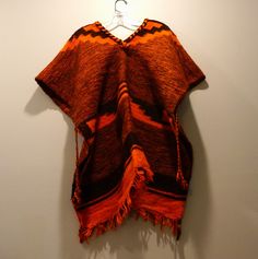 This beautiful handmade Peruvian poncho cape is a must-have for any collector of Latin American culture and history. The intricate weaving and use of high-quality wool material make this piece a true work of art. It may be Alpaca wool, but uncertain. Its vibrant burnt-orange and brown colors bring to life the Peruvian culture of this one size over the head poncho, and add a touch of authenticity to any collection.  The provenance of this item is not available, comes from a collection of 1940-1960's Peru and Pakistan outerwear items, and it is certain to be a unique and special addition to your wardrobe or home. Excellent vintage condition with some fringe disravelment, a discolored spot and a small pull; see the three photos. Should to shoulder:  31" Top to bottom:  32" Peruvian Poncho, Latin American Culture, Peruvian Culture, American Culture, Cape May, Poncho Cape, Latin American, Alpaca Wool, Orange Brown