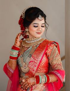 a woman in a red and gold bridal outfit