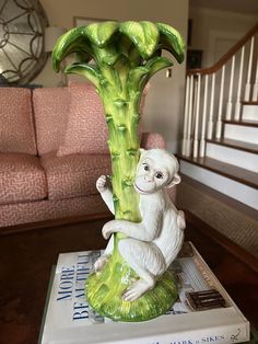 a monkey figurine sitting on top of a book in front of a couch