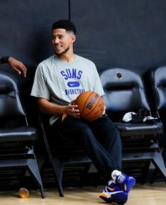 a man sitting in a chair holding a basketball