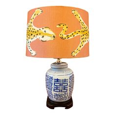 a blue and white table lamp with two cheetah on it's side